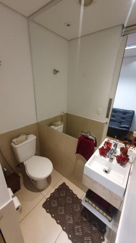 een badkamer met een toilet, een wastafel en een spiegel bij Estudio Avenida Paulista in Sao Paulo