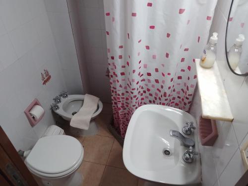 y baño con lavabo, aseo y cortina de ducha. en Departamento en el centro de Colon en Colón