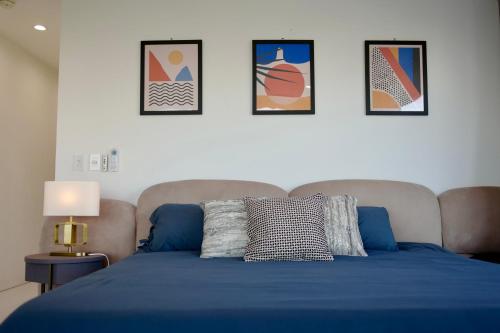 a bedroom with a blue bed with four pictures on the wall at Exclusive Hillside Hideaway-Private Room in Los Angeles