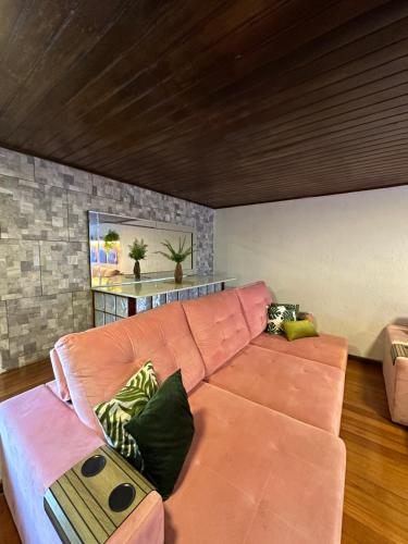 7 persons - 140 m2 - Sambódromo - LAPA - House - Casa - Netflix في ريو دي جانيرو: غرفة معيشة مع أريكة وردية في غرفة