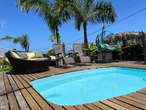 una piscina en una terraza con sillas y una hamaca en Pousada Mirante, en Florianópolis