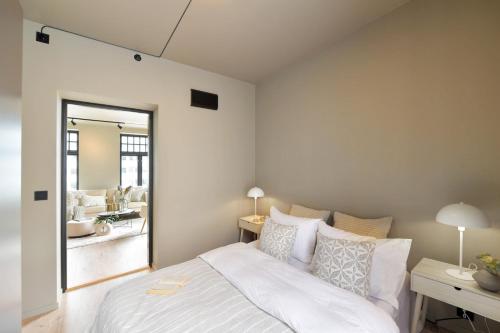 una camera con un letto bianco e un grande specchio di West Coast Apartments Aalesund ad Ålesund
