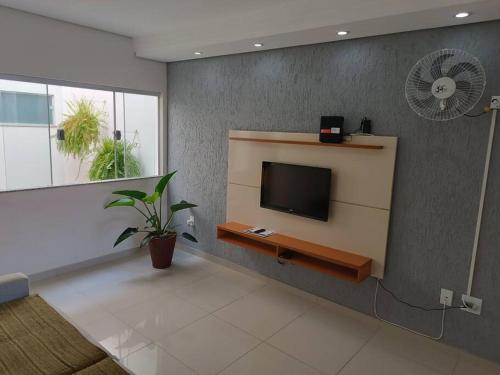 a living room with a flat screen tv on a wall at Casa de Maria in Aparecida