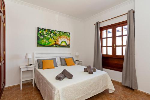 - une chambre avec un grand lit blanc et des oreillers orange dans l'établissement Playa Blanca Sunlight Apartment BY PVL, à Playa Blanca