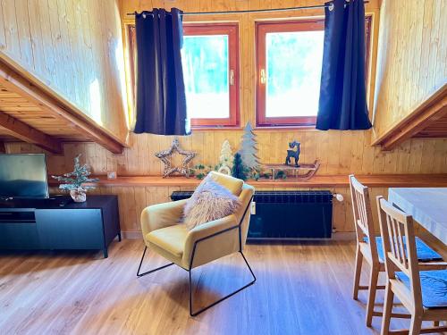 a living room with a chair and a table at Mansarda delle Dolomiti nuovissimo appartamento in Madonna di Campiglio