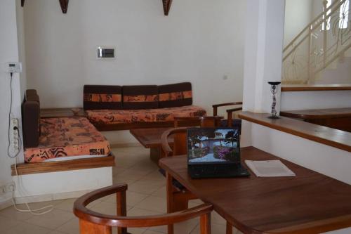 a living room with a table and chairs and a laptop at Villa Mandel Nafio, Haus mit Garten nahe dem Atlantik in Ouoran