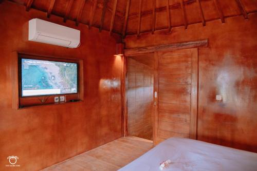 Zimmer mit einer Tür, einem Fenster und einem TV in der Unterkunft The Kori Sire in Tanjung