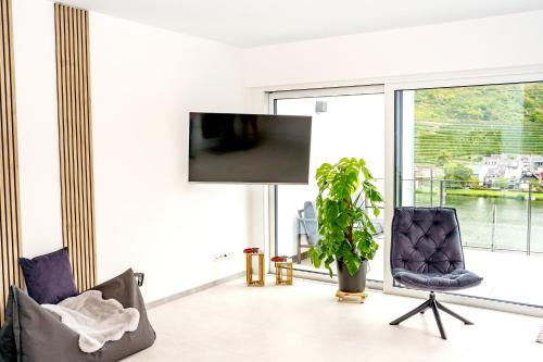 a living room with two chairs and a large window at MV Römervilla, Lofts & Penthouses mit traumhaftem Moselpanoramablick und Sauna in Treis-Karden