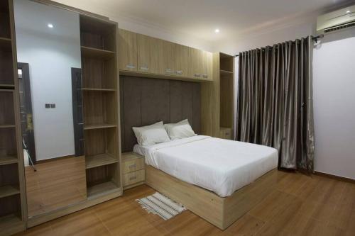 Un dormitorio con una gran cama blanca y estanterías en Unit i2 City House (Sleeps 6) en Lagos