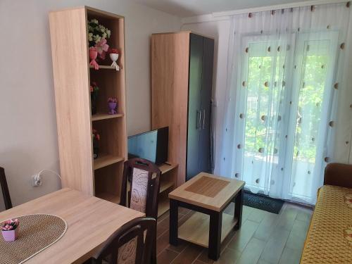 een woonkamer met een tafel en een televisie bij Smeštaj Miki 2 in Soko Banja