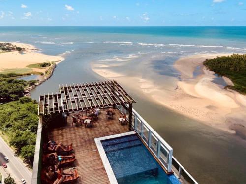 a house on a beach with a swimming pool at Ezza Experience - Beach Flat in Recife