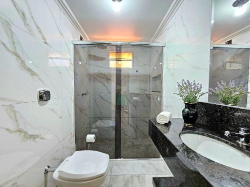 uma casa de banho com um WC, um lavatório e um chuveiro em Linda Edícula com Churrasqueira em casa de Familia em Foz do Iguaçu