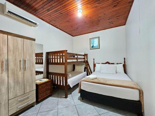 um quarto com 2 camas individuais e um tecto de madeira em Linda Edícula com Churrasqueira em casa de Familia em Foz do Iguaçu