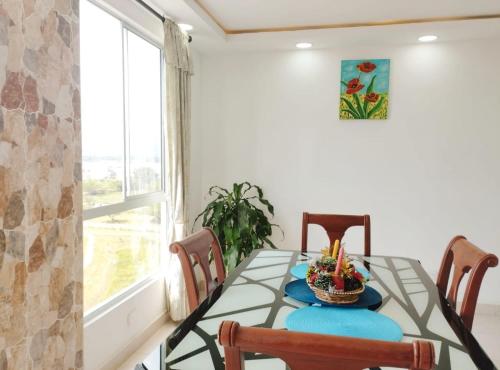 a dining room with a table and chairs and a window at Hermoso Apartamento Estancia Tranquila por dias, semanas o meses in Jamundí