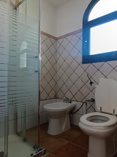 uma casa de banho com um WC, um lavatório e um chuveiro em MOANA SURF HOUSE em Corralejo