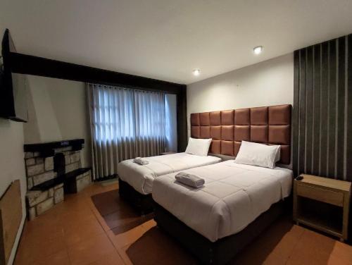 a hotel room with two beds and a television at NaturaLodge Machu Picchu in Machu Picchu