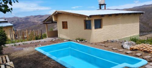 ein Haus mit einem blauen Pool davor in der Unterkunft La Nave 2 in Potrerillos