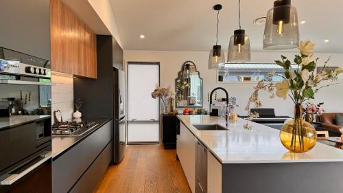 a kitchen with black and white counters and a vase with flowers at Spacious and Luxurious Family Home in Queenstown