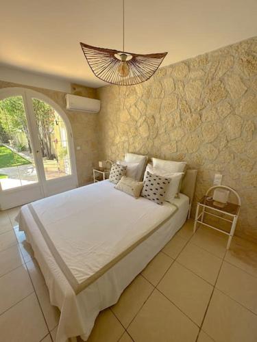 une chambre avec un grand lit et un lustre dans l'établissement La nature mezoise, à Mèze