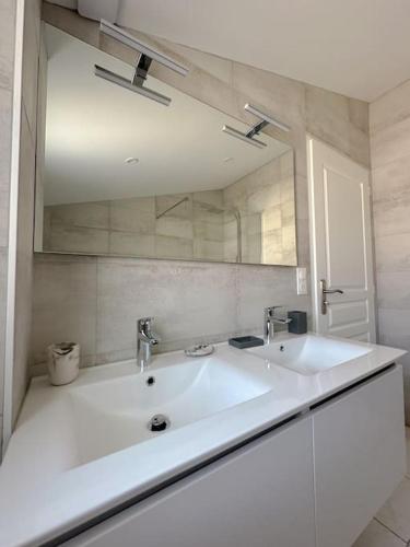 une salle de bain avec un lavabo blanc et un miroir dans l'établissement La nature mezoise, à Mèze