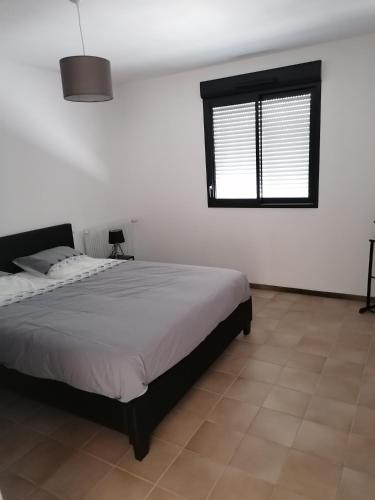 une chambre avec un grand lit et une fenêtre dans l'établissement Le petit Lambertie, à Vergt