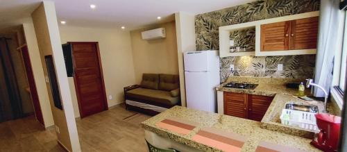 a kitchen with a refrigerator and a couch in it at Casa Alessia Novos apartamentos a 30MT do Mar em Morro de São Paulo in Morro de São Paulo