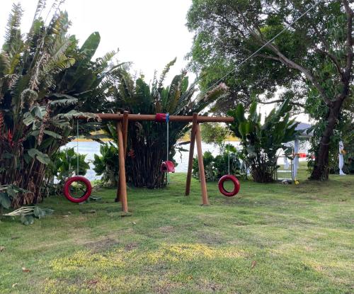 a playground in a park with red and blue swings at Guarajuba Suítes Premium Boutique Hotel in Guarajuba