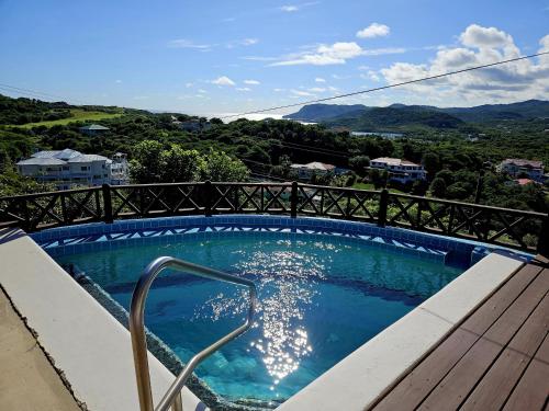 una piscina con vistas a las montañas en Charming cottage located in Cap Estate - Orchid Cottage home, en Cap Estate