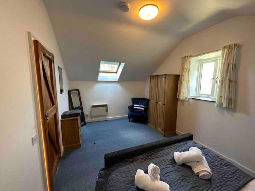 een slaapkamer met een bed met handdoeken erop bij The Coach House North Wales, Amazing views , hot tub, log fire in Halkyn