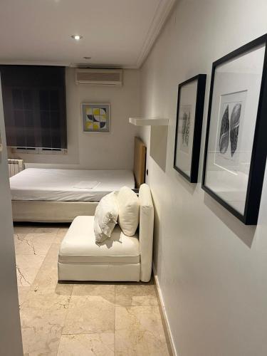 Zimmer mit 2 Betten und einem weißen Sofa in der Unterkunft Exyca Malasaña in Madrid