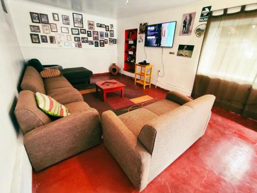 Sala de estar con 2 sofás y mesa en Hostel Rivendell, en Cusco