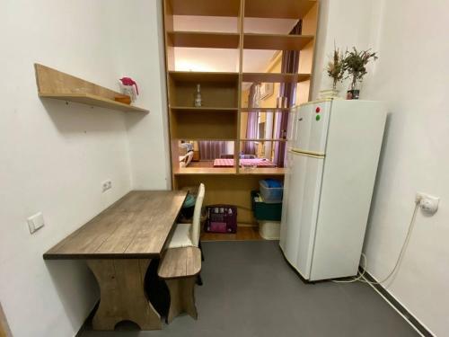 a kitchen with a wooden table and a refrigerator at Redas Villa 2 in Newquay