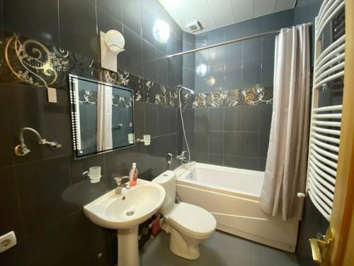 a bathroom with a sink and a toilet and a tub at Redas Villa 2 in Newquay