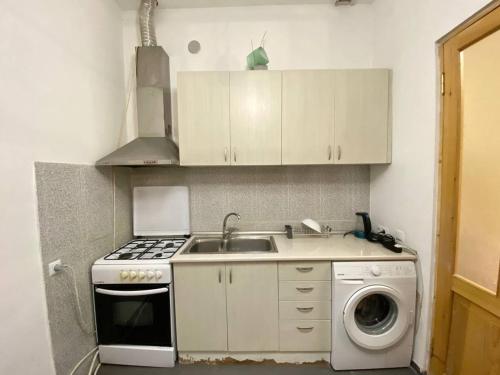 a kitchen with a sink and a washing machine at Redas Villa 2 in Newquay
