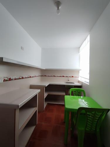 eine Küche mit einem grünen Tisch und einem grünen Stuhl in der Unterkunft Mini departamentos in Camaná