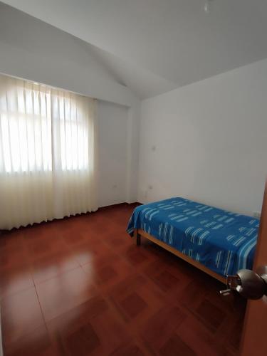 1 dormitorio con 1 cama y suelo de madera en Mini departamentos en Camaná