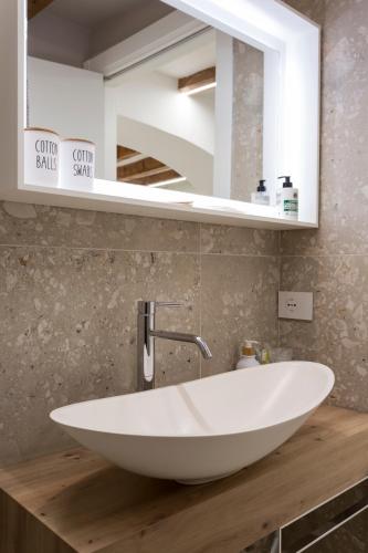 a white sink on a wooden counter in a bathroom at Moscova Luxury B&B in Milan
