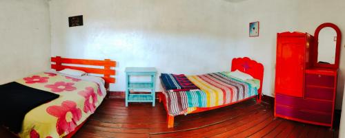 a bedroom with two beds and a table in it at Hostel Rivendell in Cusco