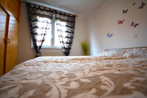 a bedroom with a bed and a window with butterflies at Apartment San Izola - near the beach in Izola