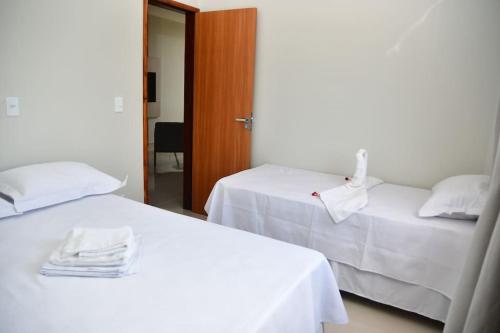 圣阿马鲁Casa das Dunas Residence até 8 pessoas (apto 3)的酒店房间里有两张床，铺着白色床单