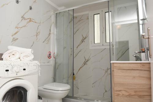 a bathroom with a toilet and a washer and dryer at Ellis house in Agrinion