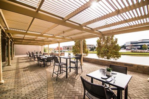 an outdoor patio with tables and chairs and a roof at Chicago Marriott Southwest at Burr Ridge in Burr Ridge
