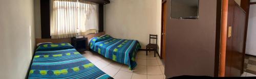 1 dormitorio con 2 camas y ventana en Hostal Marbella, en Camaná