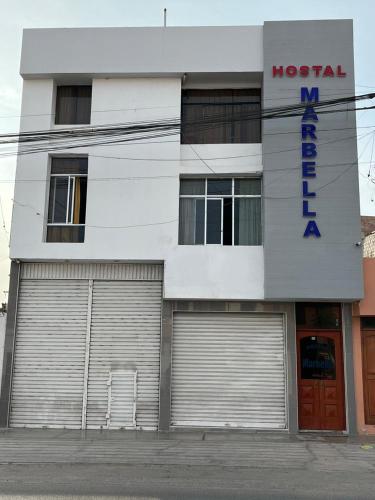 un edificio con dos puertas de garaje delante de él en Hostal Marbella, en Camaná