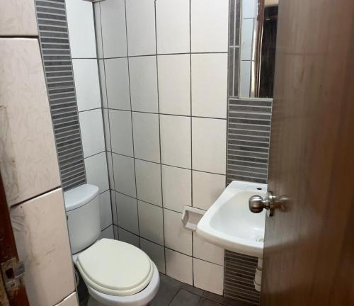 a bathroom with a toilet and a sink at Hostal Marbella in Camaná