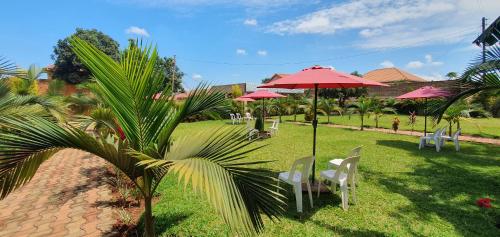 Ambur Gardens Nalya في كامبالا: مجموعة طاولات وكراسي مع مظلات
