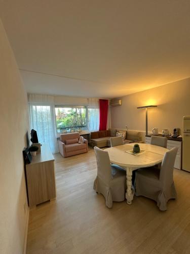 ein großes Wohnzimmer mit einem Tisch und Stühlen in der Unterkunft Holiday on The Lake Lugano 2 in Bissone