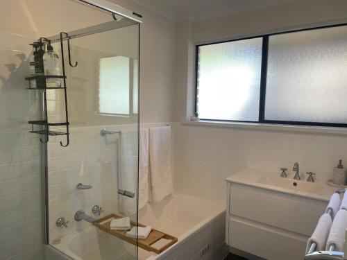 a bathroom with a shower and a tub and a sink at Homburg Haven in Tanunda