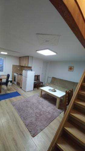 a living room with a table and a kitchen at Kopaonik Apartman Aleksandar in Kopaonik