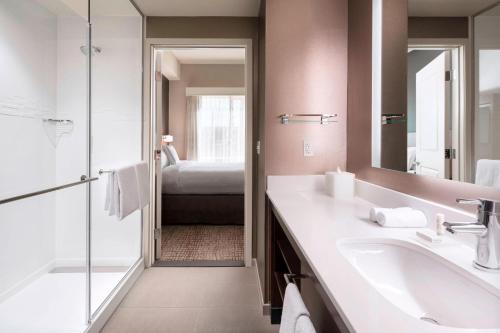 un bagno con lavandino, specchio e letto di Residence Inn by Marriott Redwood City San Carlos a San Carlos